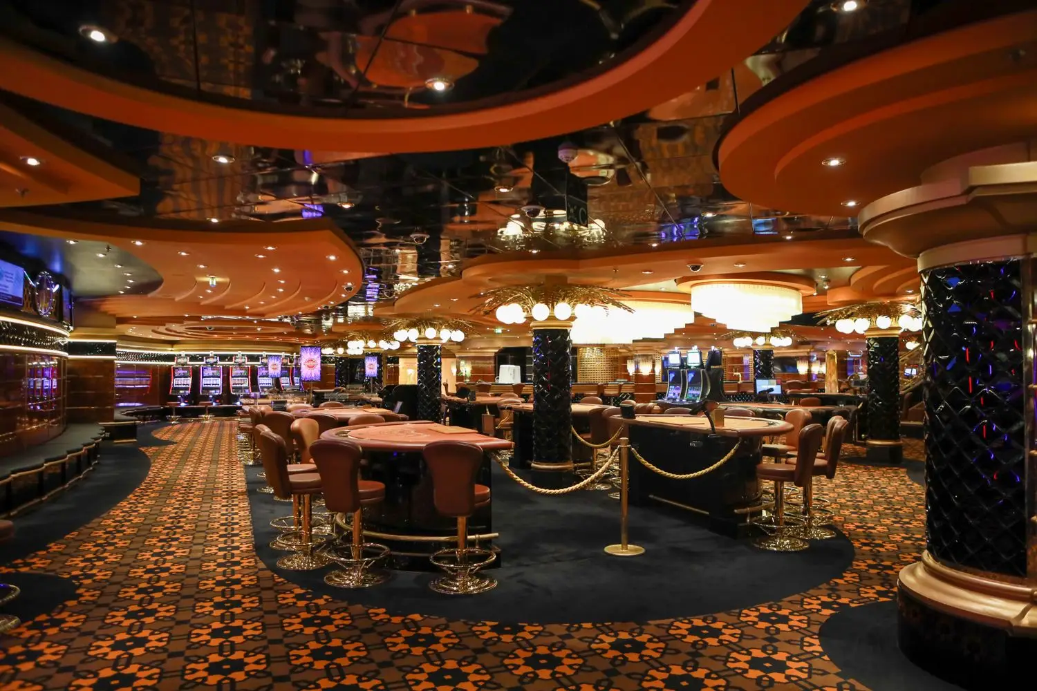 Casino floor with table games and warm overhead lighting