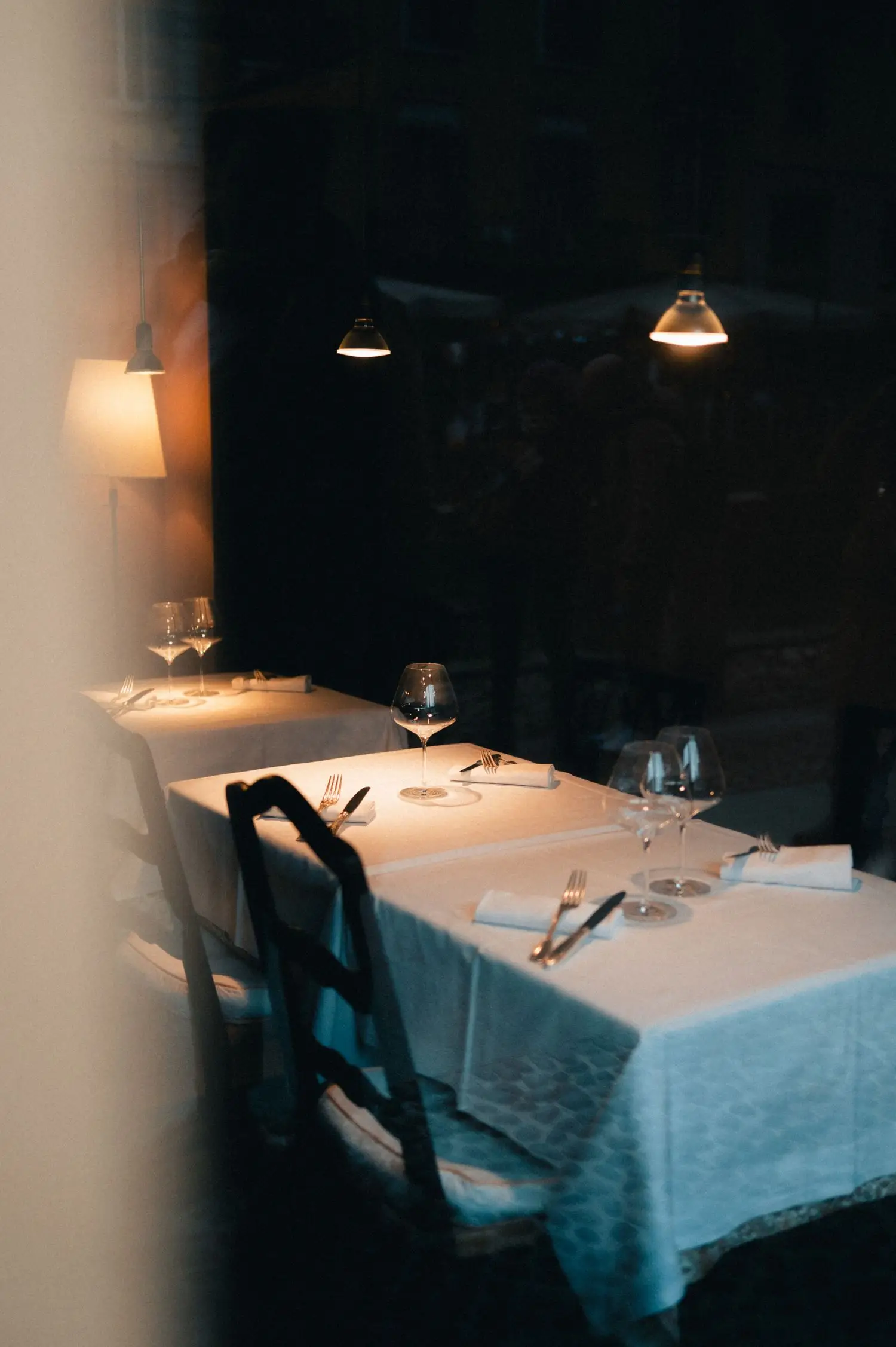 Intimate white-tablecloth seating in low light