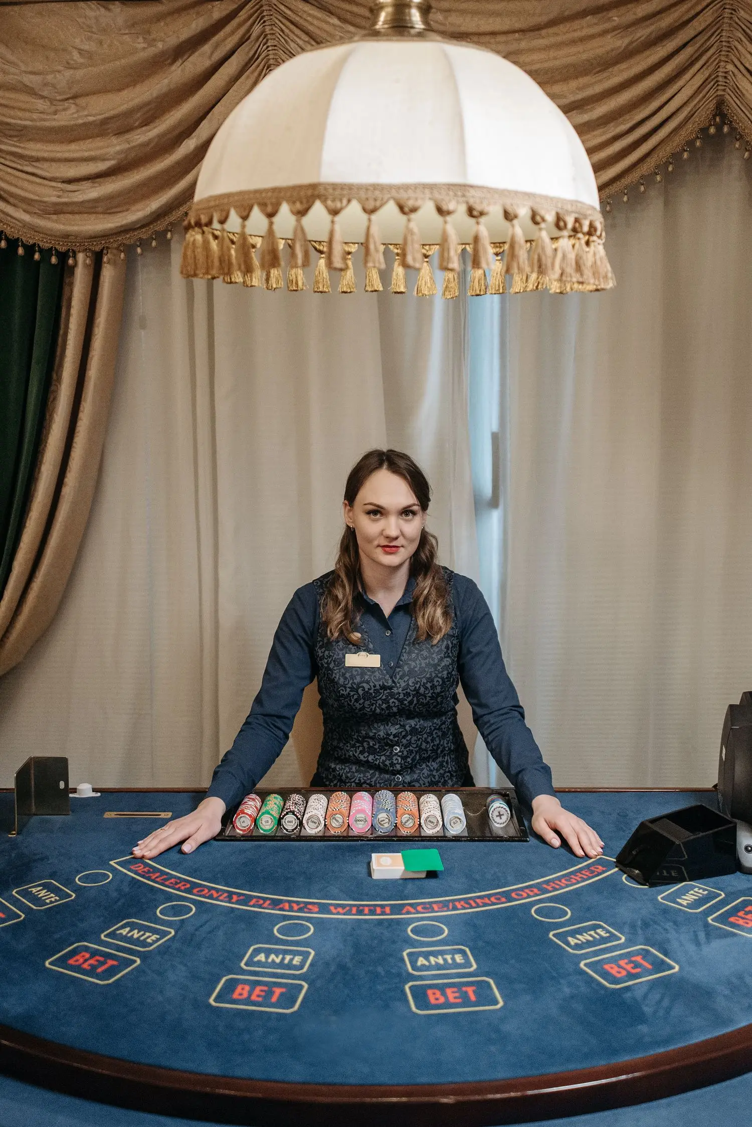 Casino dealer standing behind a gaming table