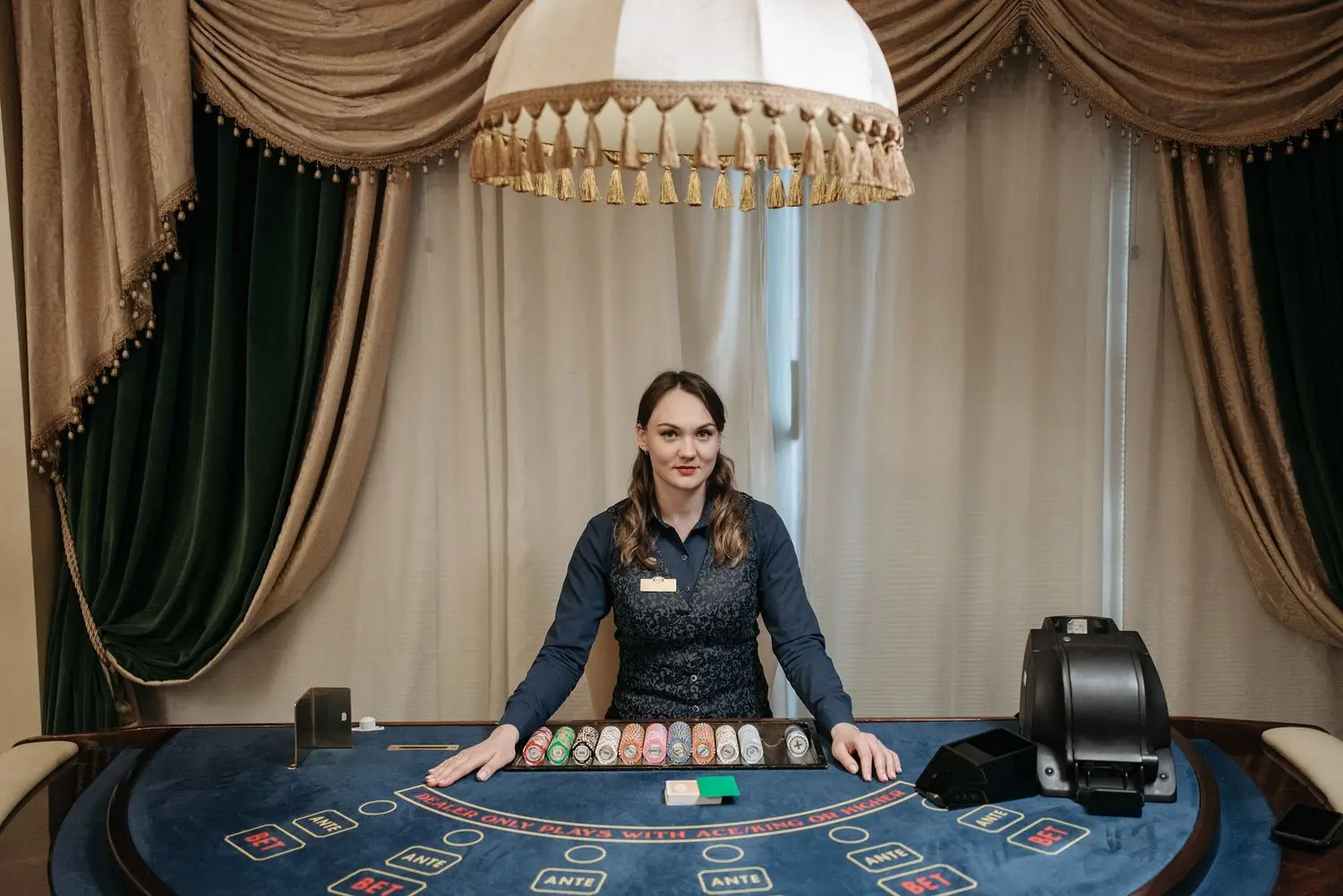 Casino dealer at a table in a softly lit room