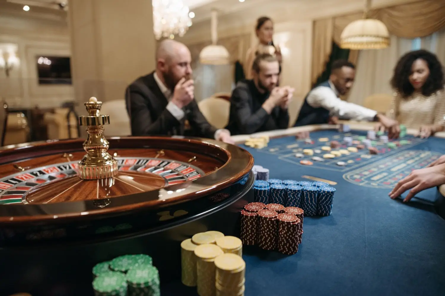 Guests around a roulette table in a casino room